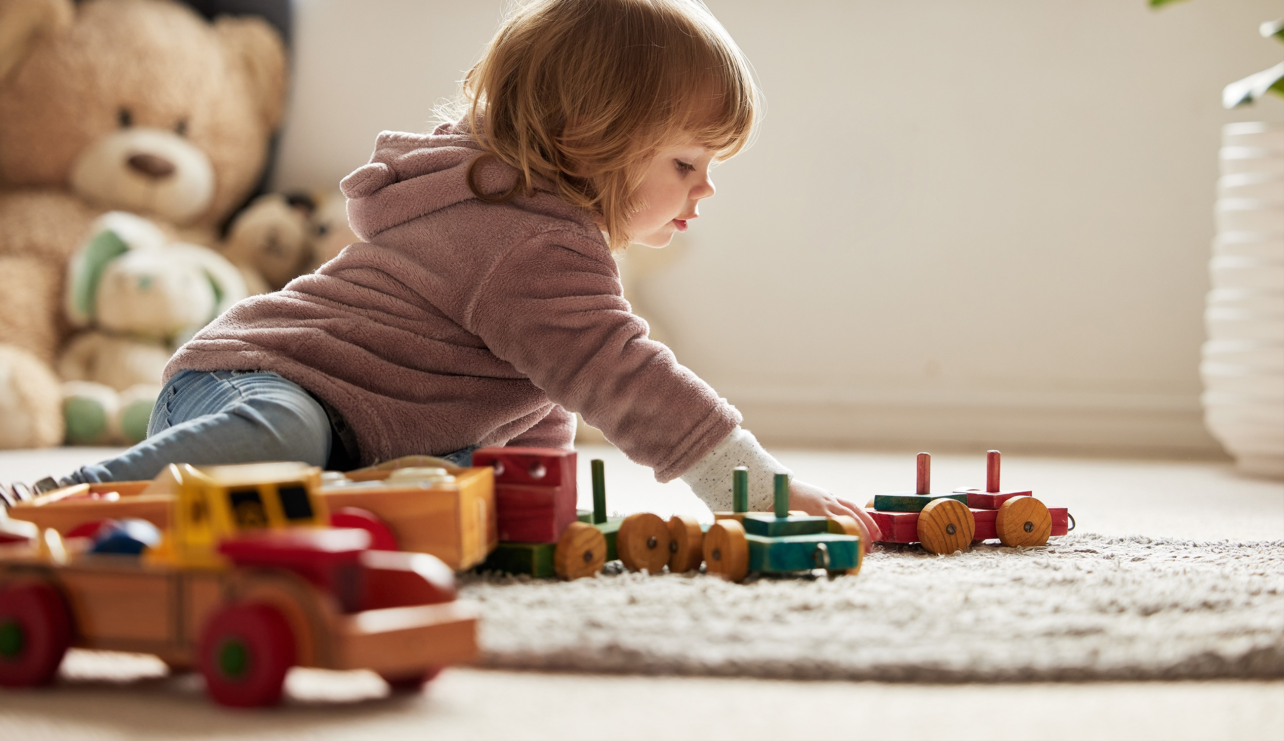 Bambini che giocano con giochi in legno ALDI su un tappeto