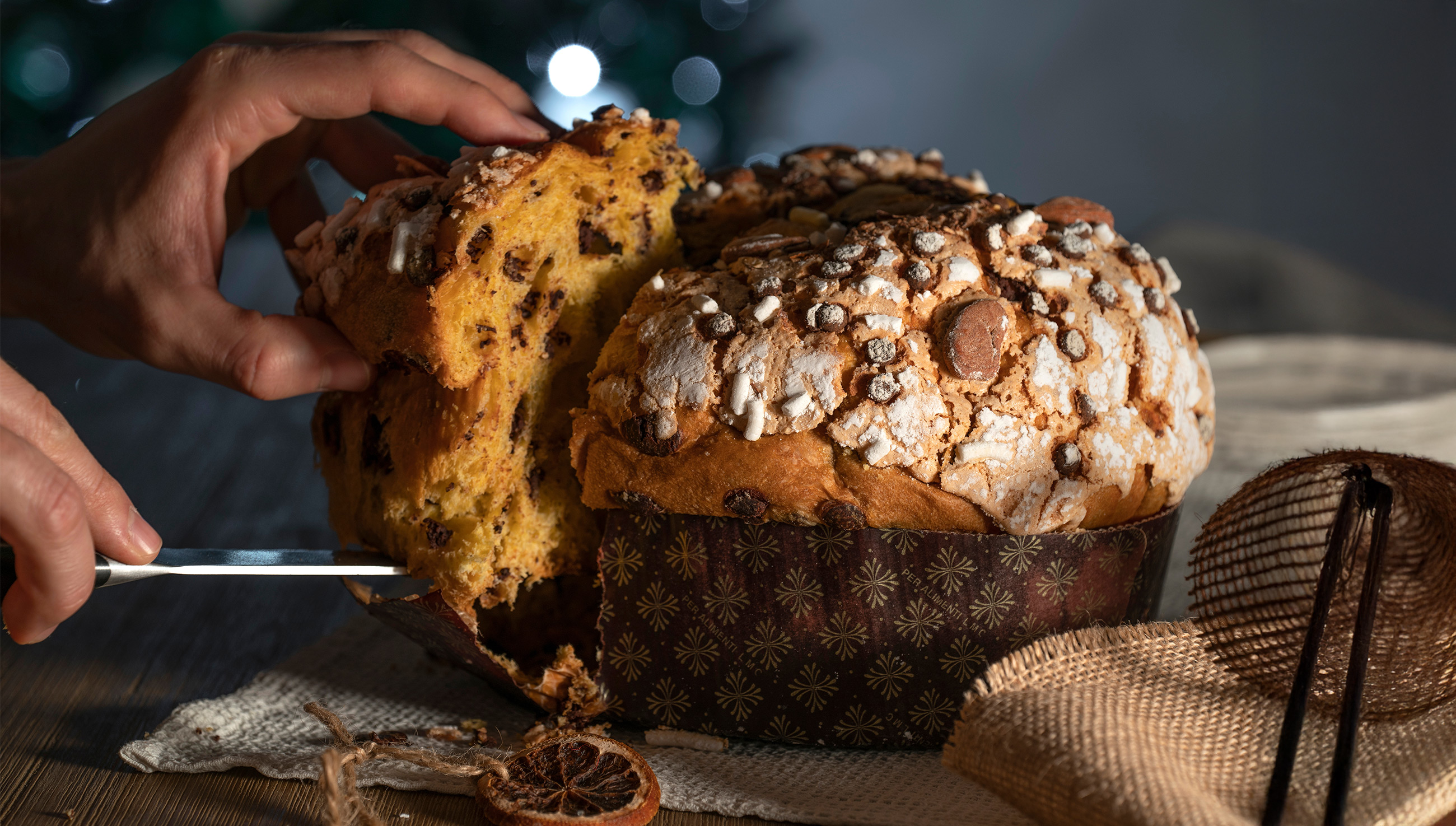 Panettone tagliato su tavola in legno con canditi e uvetta